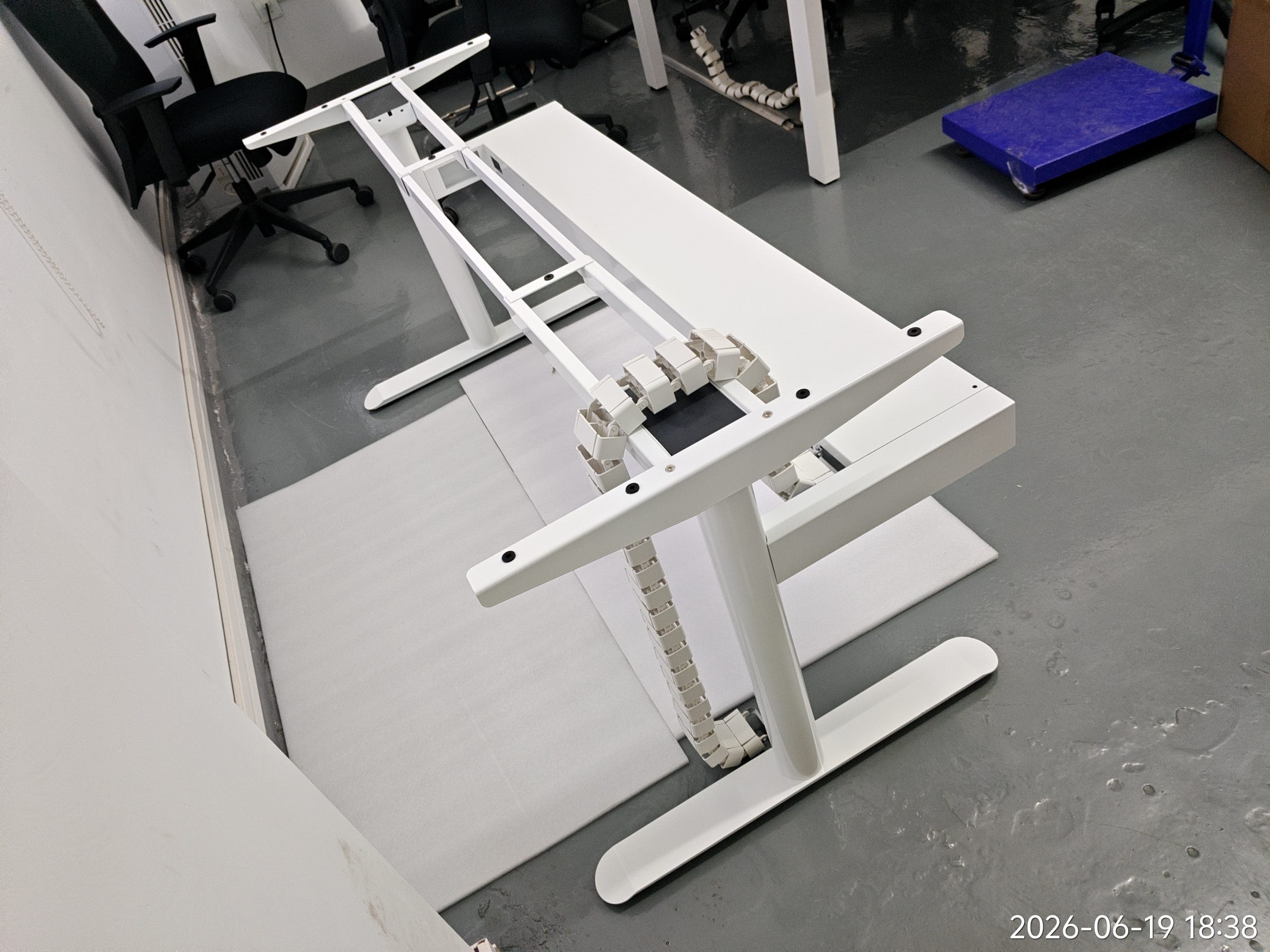 Standing desk frames with cable trays and control systems during configuration